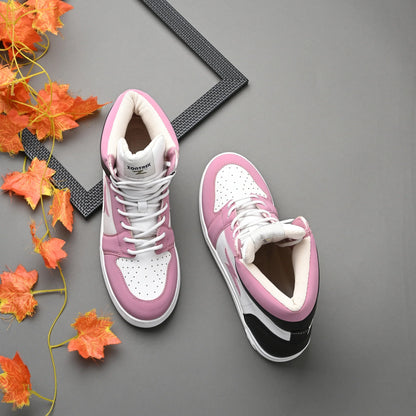 Pink and white sneakers with a black sole on a gray surface with orange leaves.