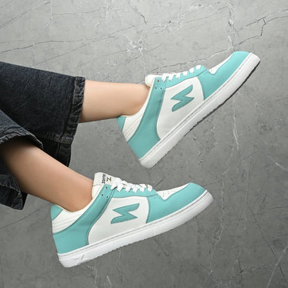 Teal and white sneakers on a gray pavement