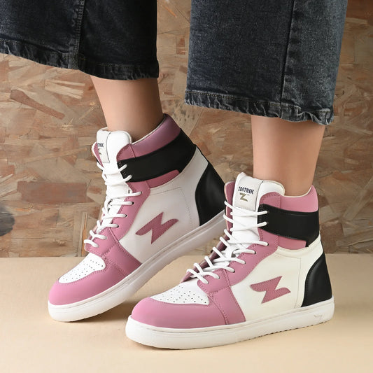 Pink and white sneakers with black accents worn by a person on a wooden floor.