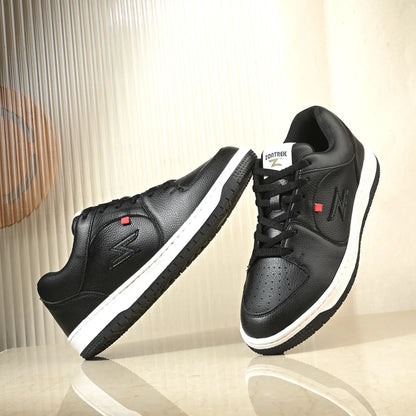 Black sneakers with white soles on a reflective surface