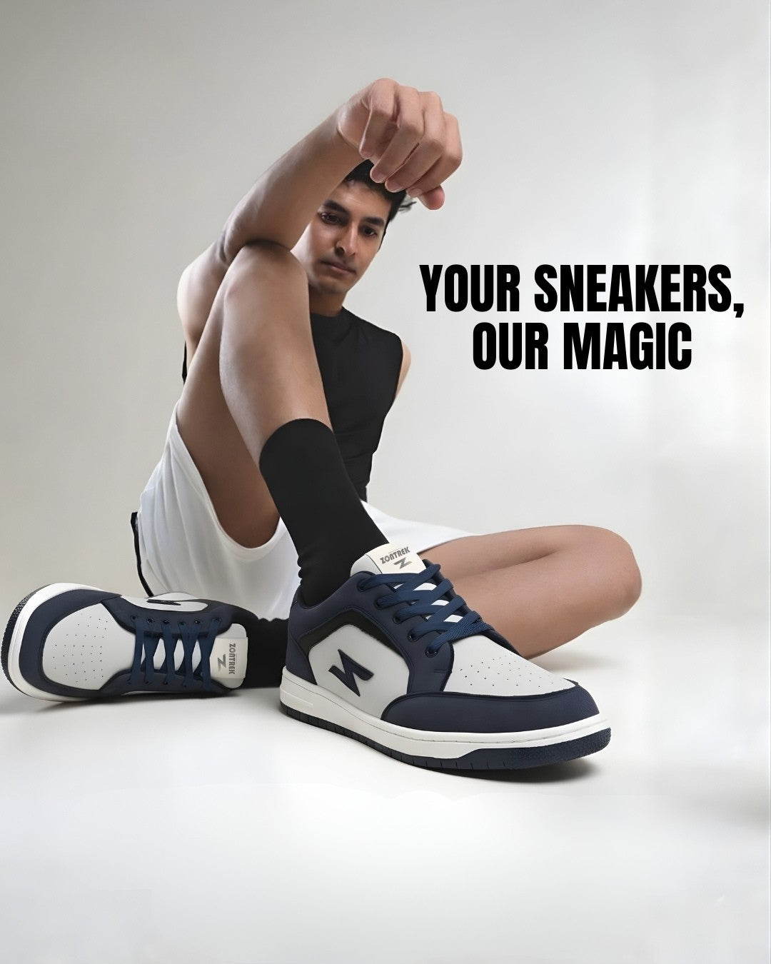 Person wearing navy and white sneakers with text 'Your Sneakers, Our Magic' on a light gray background